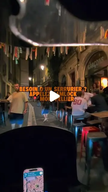 Vue depuis la moto de SamLock, de nuit, dans une rue animée du centre de Montpellier