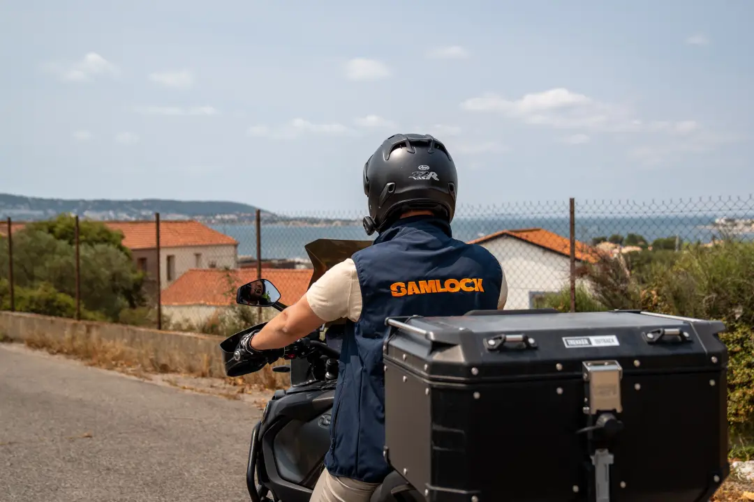 Sami en route à moto, gilet SamLock sur le dos, au-dessus de la mer près de Montpellier